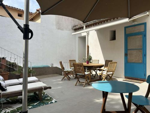 un patio avec une table, des chaises et un parasol dans l'établissement Charmant 3 pièces avec terrasse et jardin, climatisé, proche plage et centre, 4 pers. - FR-1-225C-130, à Banyuls-sur-Mer