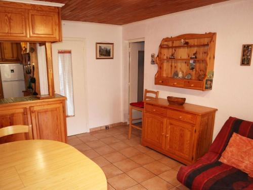 une cuisine avec des placards en bois, une table et une chaise dans l'établissement T2 chaleureux 6 pers, Les Orres 1650, calme, proche remontées et commerces - FR-1-322-580, aux Orres
