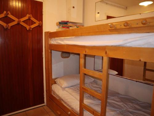 une chambre avec deux lits superposés et un miroir dans l'établissement T2 chaleureux 6 pers, Les Orres 1650, calme, proche remontées et commerces - FR-1-322-580, aux Orres