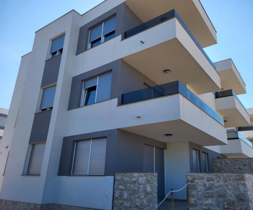 a building with balconies on the side of it at Apartment Mare D with a pool new in Novalja