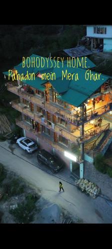 a large building with a sign for a hotel at BohOdyssey Hallan a Traditional Village Stay with Panoramic Mountain Views in Nagar