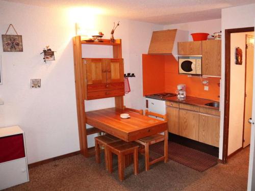 une petite cuisine avec une table en bois et une étagère dans l'établissement Studio calme, balcon, à 100m des pistes et commerces - idéal pour 4 personnes - FR-1-322-579, aux Orres