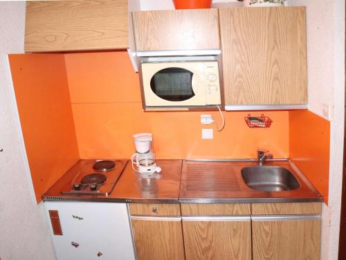 une petite cuisine avec un évier et un micro-ondes dans l'établissement Studio calme, balcon, à 100m des pistes et commerces - idéal pour 4 personnes - FR-1-322-579, aux Orres