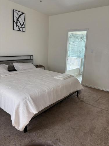 a bedroom with a large white bed and a window at Elegant family home in Cypress