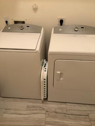 two refrigerators sitting next to each other in a room at Elegant family home in Cypress