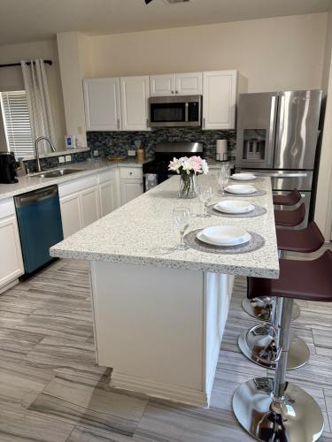 a kitchen with a counter with wine glasses on it at Elegant family home in Cypress