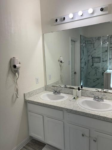 a bathroom with two sinks and a large mirror at Elegant family home in Cypress