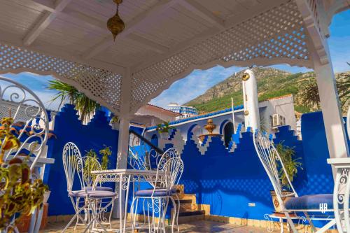 a room with blue walls and chairs and a mural of a cruise ship at PALACIO AL ANDALUS in Chefchaouene