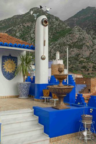 a blue and white building with a fountain at PALACIO AL ANDALUS in Chefchaouene