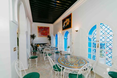 a room with white tables and chairs and windows at PALACIO AL ANDALUS in Chefchaouene