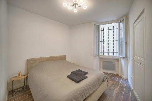 une chambre blanche avec un lit et une fenêtre dans l'établissement Cannes hyper centre quartier historique du suquet -palais-croisette, à Cannes