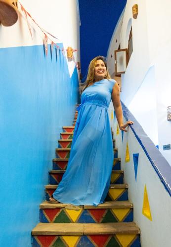 a woman in a blue dress walking down stairs at DoroKa Nubian House in Aswan