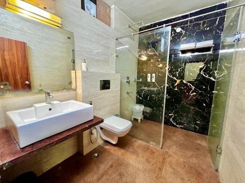 a bathroom with a sink and a toilet and a shower at The Paradiso Corbett Resort - Top Rated & Most Awarded Property in Jim Corbett in Rāmnagar