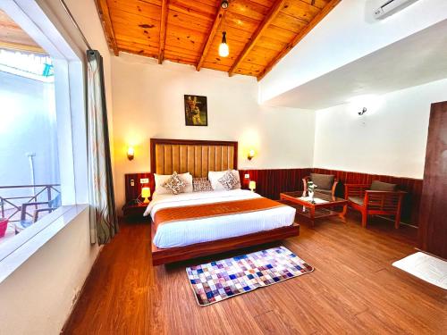 a bedroom with a bed in a room with wooden floors at The Paradiso Corbett Resort - Top Rated & Most Awarded Property in Jim Corbett in Rāmnagar