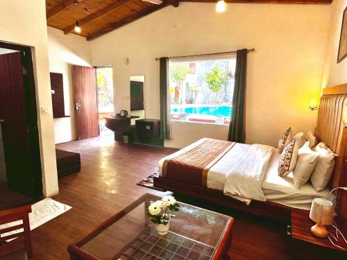 a bedroom with a bed and a living room at The Paradiso Corbett Resort - Top Rated & Most Awarded Property in Jim Corbett in Rāmnagar