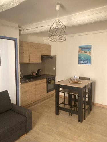 a kitchen with a table and a couch in a room at Bandol Studio à deux pas du port in Bandol