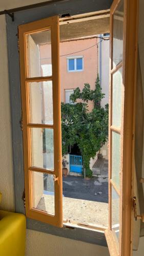 une fenêtre ouverte avec vue sur un bâtiment dans l'établissement Appartement pêcheur, à Sète