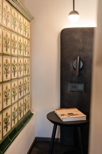 a table with a book on it next to a wall at Schwarzer Adler - Concept Living in Vipiteno