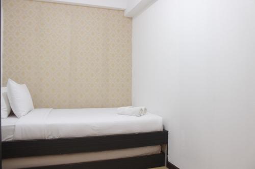 a bedroom with a bed with white sheets at Deluxe & Comfy 2BR at Braga City Walk Apartment By Travelio in Bandung