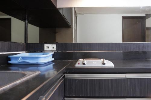 a kitchen with a stove and a sink at Deluxe & Comfy 2BR at Braga City Walk Apartment By Travelio in Bandung