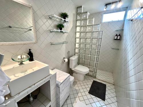 a white bathroom with a toilet and a sink at Vista Inesquecível de São Paulo! in Sao Paulo