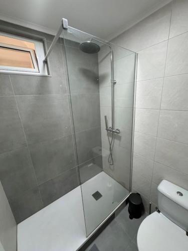 a bathroom with a shower with a glass door at The Crow Ajuda Apartment I in Lisbon