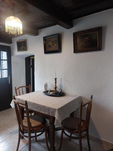 a dining room with a table and chairs and a chandelier at Babamúzeum apartman in Tihany
