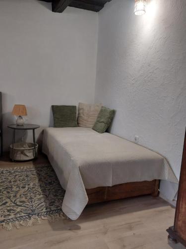 a bedroom with a bed in a white room at Babamúzeum apartman in Tihany