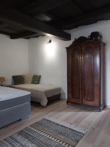 a bedroom with a bed and a wooden cabinet at Babamúzeum apartman in Tihany