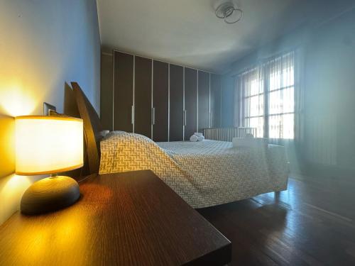 a bedroom with a bed and a table with a lamp at Chicco family - Appartamento spazioso per famiglie e soggiorni business - Cinelli Apartment in Vercelli