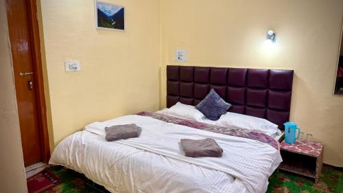 a bedroom with a large bed with two pillows on it at Al Hayat Guest House in Pahalgām