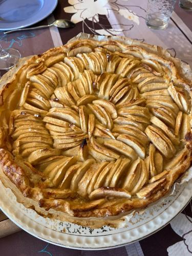 a pie sitting on a plate on a table at Le Domaine d'Élise Chambres et table d'hôtes - Vosges in Saint-Ouen-lès-Parey
