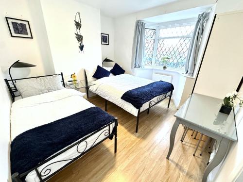 a bedroom with two beds and a window at 3 Twin Bedroom Entire House Sleeps 10 Driveway Parking near Coventry University and City Center in Coventry