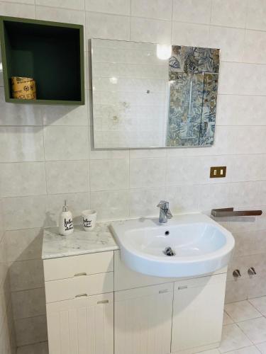 a white bathroom with a sink and a mirror at A casa di Vanna in San Donà di Piave