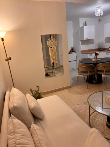 a living room with a couch and a table at Cosy T2 neuf avec balcon Proche centre & plage in Montpellier
