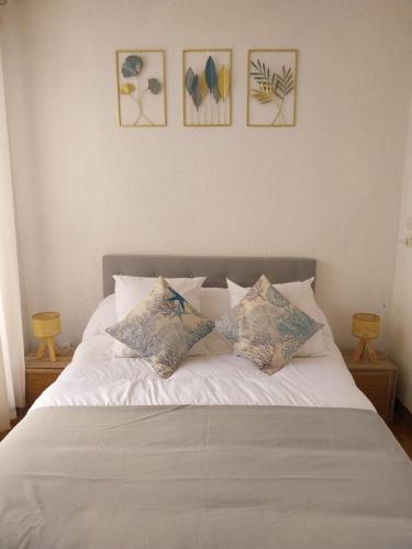 - un lit blanc avec 4 oreillers dans l'établissement Le Quai401 YourHostHelper, à Gruissan