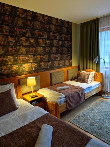 a hotel room with two beds and a window at Sólyomvár-Lak in Komlóska