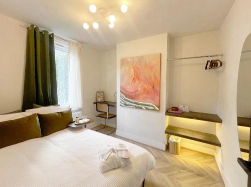 a bedroom with a bed and a painting on the wall at Modern Terrace home - 2 bedroom - University Hospital City Centre in Reading