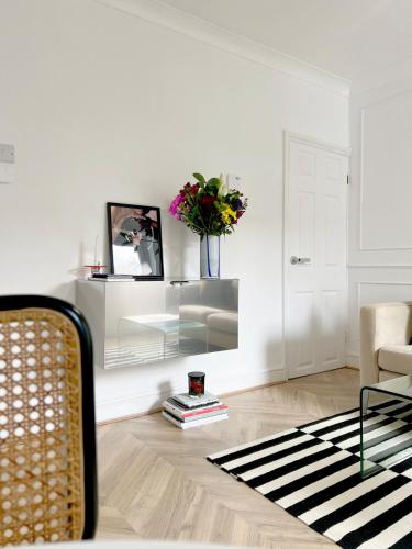 a living room with a vase of flowers on the wall at Modern Terrace home - 2 bedroom - University Hospital City Centre in Reading