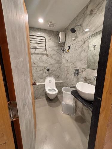 a bathroom with a toilet and a sink at Hotel Sparsh Inn in Ahmedabad