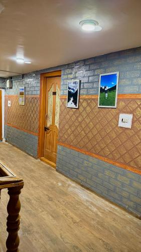 a room with a brick wall with pictures on it at Al Hayat Guest House in Pahalgām