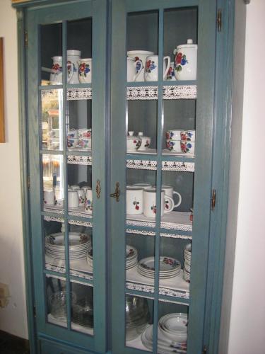 a blue cabinet filled with cups and saucers at Villa Emilia in Kals am Großglockner