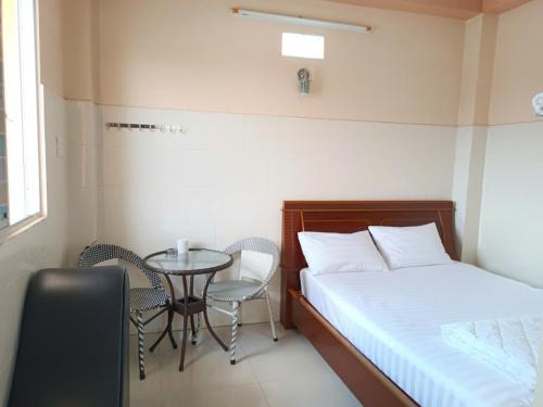 a small room with a bed and a table and chairs at Nhà Nghỉ Tân An in Ấp Bình Quang