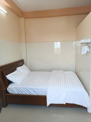 a bedroom with a large bed with white sheets at Nhà Nghỉ Tân An in Ấp Bình Quang