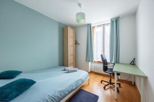 une chambre avec un lit, un bureau et un ordinateur dans l'établissement Calme Appart - Centre ville - Cozy Houses, à Reims