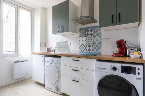 une cuisine blanche avec un lave-linge et un sèche-linge. dans l'établissement Calme Appart - Centre ville - Cozy Houses, à Reims