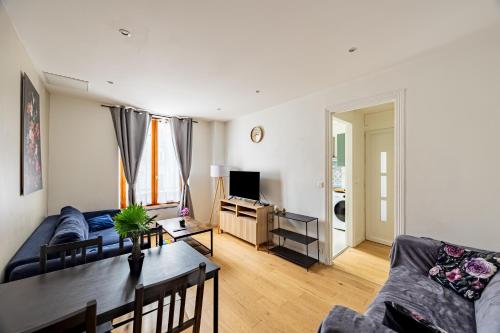 un salon avec un canapé et une table dans l'établissement Calme Appart - Centre ville - Cozy Houses, à Reims