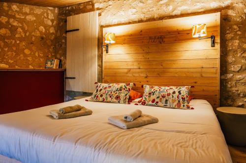 un grand lit blanc avec deux oreillers dessus dans l'établissement Le Mas du Bout, à Eygalières