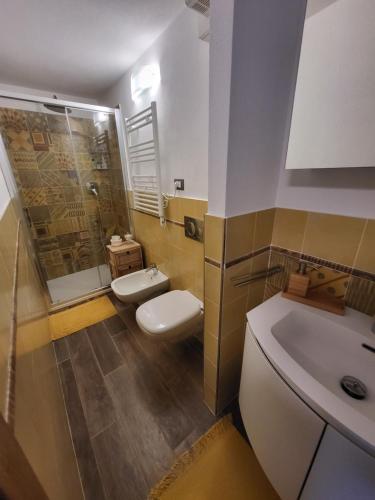 a bathroom with two toilets and a shower and a sink at La casetta sul mare in San Bernardino