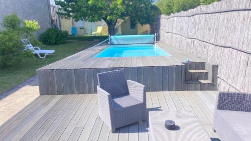 une terrasse avec une chaise et une piscine dans l'établissement La grande Escapade idéal familles, piscine, netflix, à Coulounieix-Chamiers